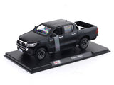 Model of a black Toyota Hilux on a display stand with a white background